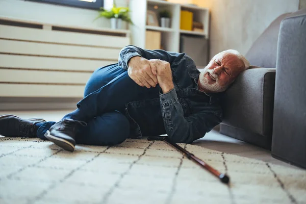 Elderly Senior Man Slip And Fall. Fallen Old Person in the Living Room.  Senior man falling down on carpet and lying on the floor in living room at home, Falls of older adults concept