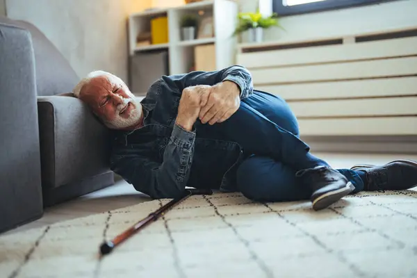 Elderly Senior Man Slip And Fall. Fallen Old Person in the Living Room.  Senior man falling down on carpet and lying on the floor in living room at home, Falls of older adults concept