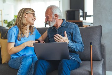 Huzurevi, bakım ve yaşlılara yardım hizmeti. Dost canlısı gülümseyen hemşire iyi analiz sonuçları veriyor ya da dizüstü bilgisayardan yaşlı yaşlı hastaya yardım ediyor. 