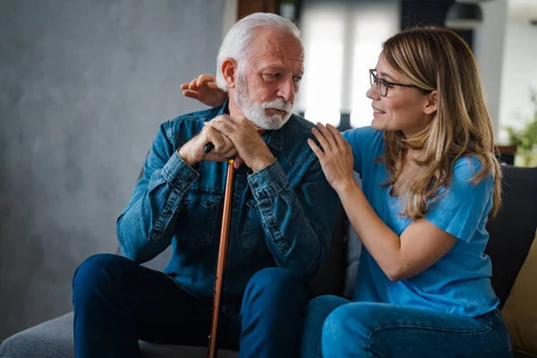 Young nurse spend time with old man, shares his pain, express empathy caring about 80s patient provide psychological support listens his life health complaints in diseases, relieves loneliness concept