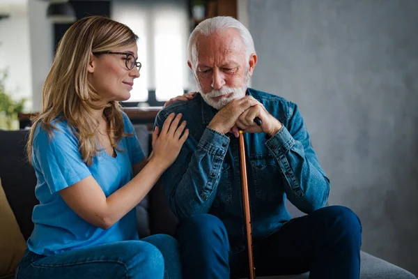 Young nurse spend time with old man, shares his pain, express empathy caring about 80s patient provide psychological support listens his life health complaints in diseases, relieves loneliness concept