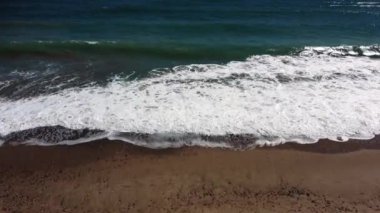 Kumsaldan dalgalara doğru ilerleyin. Video 4K.