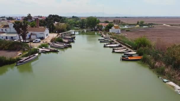 一架无人驾驶飞机飞越一座小村庄的河上的一座桥 停泊在码头的船只 — 图库视频影像
