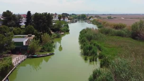 无人机与小村庄沿着河边飞行 停泊在码头的船只 — 图库视频影像