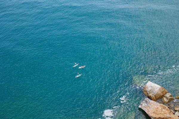 Людини Веслують Дошках Суп Уздовж Скелястого Берега Гігантськими Каменями Вид — стокове фото