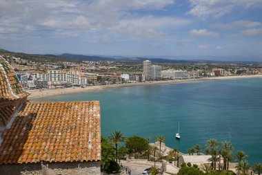 İspanya. Valencia, Peniscola. Peniscola Kalesi 'nin yüksekliğinden sahili görmek. Çok güzel bir Akdeniz manzarası ve küçük bir kasaba. Arka planda dağ yamacında birçok ev var..