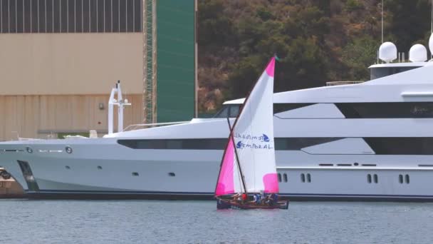 スペイン カルタヘナ 2023年4月30日 チームは大きなヨットを背景にカルタヘナの港で小型帆船のナビゲーションを練習しています — ストック動画