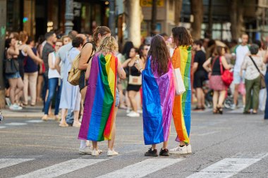 Valencia, İspanya - 24 Haziran 2023: Valencia 'da insanlar LGBT Gay Pride' ı kutluyorlar. Çok renkli gökkuşağı bayraklı kızlar. Homoseksüel, lezbiyen, insan hakları, Igbt gurur kavramı.