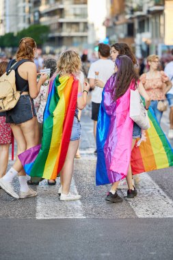 Valencia, İspanya - 24 Haziran 2023: Valencia 'da insanlar LGBT Gay Pride' ı kutluyorlar. Çok renkli gökkuşağı bayraklı kızlar. Homoseksüel, lezbiyen, insan hakları, Igbt gurur kavramı.