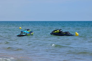 Two Personal Watercraft (jet ski) waiting for riders in front of the beach in Valencia clipart