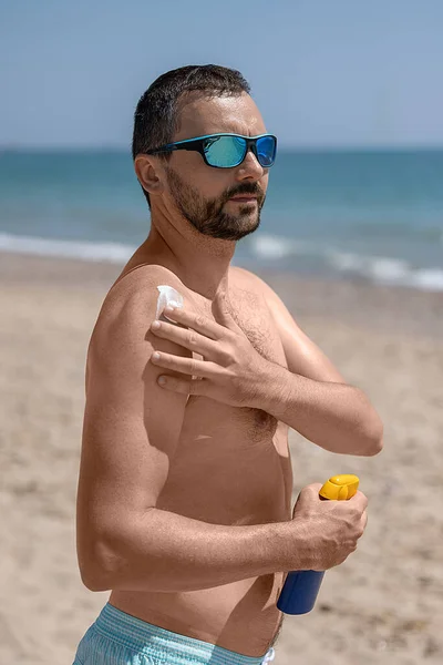 Young White Man Sunglasses Beard Applying Sunscreen Beach Mediterranean Sea — Stock Photo, Image