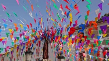 Eski bir kasabanın meydanında çeşitli renklerde renkli üçgen bayraklar şeklinde dekorasyon. Guadalest, İspanya.