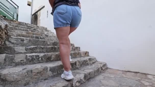 Una Chica Zapatillas Pantalones Cortos Mezclilla Sube Las Escaleras Piedra — Vídeo de stock