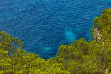 Sıcak bir yaz gününde, dağdan deniz koyunun çam ağaçlarıyla kaplı görüntüsü. Granadella Plajı, Costa Blanca, İspanya.