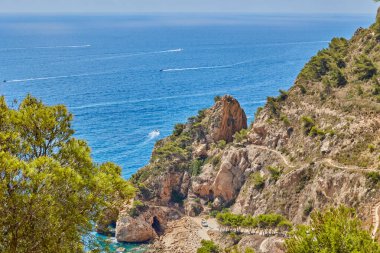 Sıcak bir yaz gününde, dağdan deniz koyunun çam ağaçlarıyla kaplı görüntüsü. Granadella Plajı, Costa Blanca, İspanya.