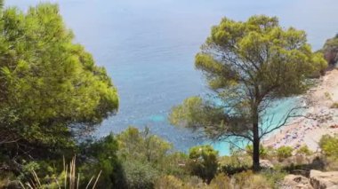 Dağdan güzel bir sahile uçurumlar, mavi gökyüzü ve gök mavisi Akdeniz 'le çevrili bir körfez. Cala del Moraig Plajı, Benitatxell, Alicante, İspanya.