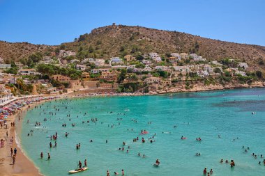 El Portet plajı, Moraira, Alicante, İspanya - 15 Ağustos 2023: İspanya 'nın Cala El Portet, Kosta Blanca bölgesi olarak da bilinen temiz turkuaz suyu olan küçük ve güzel bir kumlu sahil manzarası.