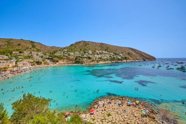 El Portet plajı, Moraira, Alicante, İspanya - 15 Ağustos 2023: İspanya 'nın Cala El Portet, Kosta Blanca bölgesi olarak da bilinen temiz turkuaz suyu olan küçük ve güzel bir kumlu sahil manzarası.