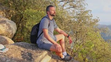 Dağın tepesinde yalnız bir adam oturuyor. Keşif gezisindeki maceraperest. Özgürlük, Zen konsepti 4k. El Garbi, Valencia, İspanya.