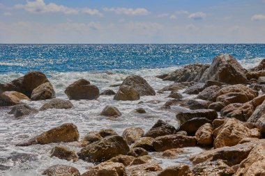 Dalgalar gün boyunca Akdeniz kıyılarında kayalara çarpıp çarpıyor. Cala del Moraig plajı Benitachell, Alicante, İspanya.
