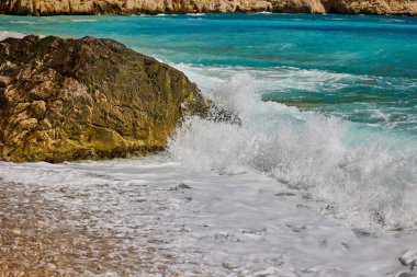 Dalgalar gün boyunca Akdeniz kıyılarında kayalara çarpıp çarpıyor. Cala del Moraig plajı Benitachell, Alicante, İspanya.