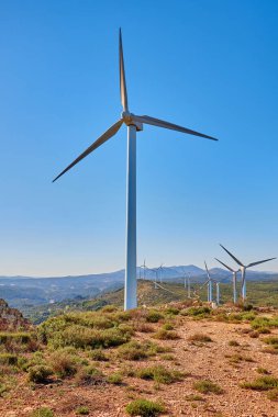 Güneşli yaz manzarasında rüzgar türbinleri. Yeşil ekolojik enerji üretimi. Bunol rüzgar çiftliği, İspanya.