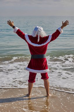 Sıcak bir yaz gününde Noel Baba denizde. Bileğine kadar suya batmış, pantolonunu sıyırmış. Noel ya da sıcak ülkelerde yeni yıl tatili. Noel Baba 'nın yaz tatili.