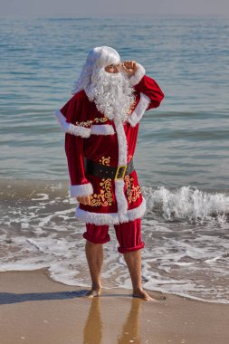 Sıcak bir yaz gününde Noel Baba denizde. Bileğine kadar suya batmış, pantolonunu sıyırmış. Noel ya da sıcak ülkelerde yeni yıl tatili. Noel Baba 'nın yaz tatili.