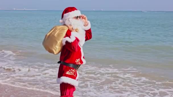 Santa Claus Con Una Bolsa Regalos Hombro Camina Largo Playa — Vídeo de stock