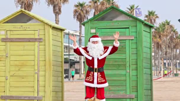Santa Claus Camina Playa Más Allá Las Cabañas Playa Multicolores — Vídeo de stock