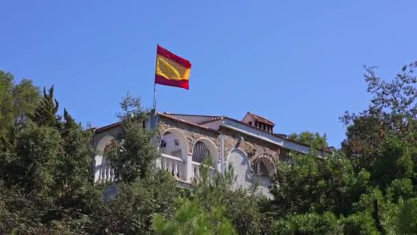 바람에 스페인 Flutters 나무로 둘러싸인 언덕에 서있는 지붕에 스페인 배경에 — 비디오