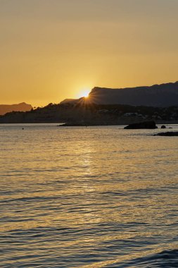 Akdeniz 'de sakin bir körfezde güzel bir gün batımı ve uçurum.