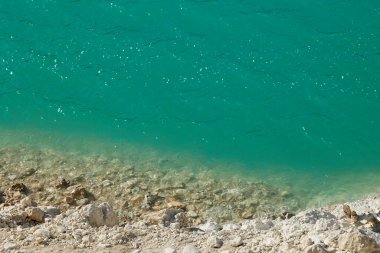 Guadalest Barajı 'nın kıyı şeridi. Kıyıdaki temiz turkuaz su ve kayaların güzel manzarası..