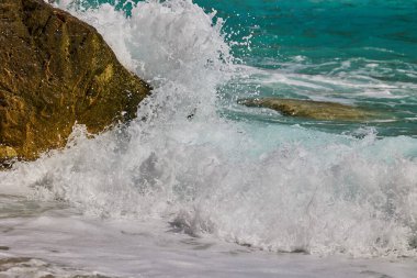 Dalgalar gün boyunca Akdeniz kıyılarında kayalara çarpıp çarpıyor. Cala del Moraig plajı Benitachell, Alicante, İspanya.