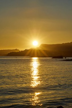 Akdeniz 'de sakin bir körfezde güzel bir gün batımı ve uçurum.