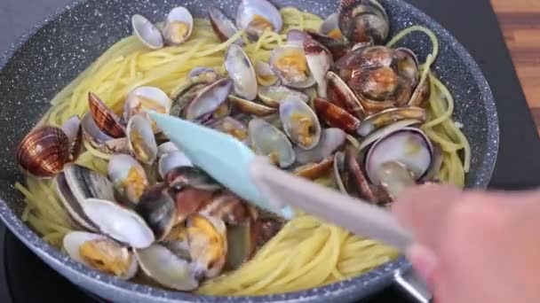 클램과 전통적인 이탈리아 해산물 파스타 스파게티 Vongole 요리사는 주걱과 조개와 — 비디오