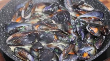 Aromatik otlar ve krema sosuyla hazırlanmış buharda pişirilmiş Akdeniz midyelerinin yakın çekimi..