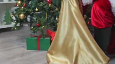Noel Baba Noel ağacının altına hediyeler koyar. Noel Baba 'nın botu ve bir çanta dolusu hediye. Noel Baba 'nın eli hediyeleri çantadan çıkarır ve Noel ağacının altına koyar..
