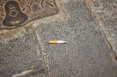 A cigarette butt thrown on the pavement