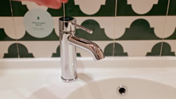 一个男人的手打开和关闭了浴室的水龙头 水在摄像机前流动 — 图库视频影像