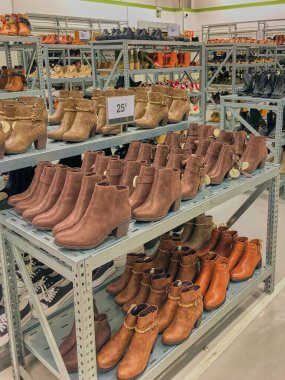 Mağazadaki raflarda alınmayı bekleyen bir sürü sonbahar ayakkabısı var. İndirim sezonu.