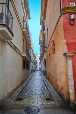 İspanya, Sevilla 'nın eski merkezinde taş kaldırımlı dar bir sokak..