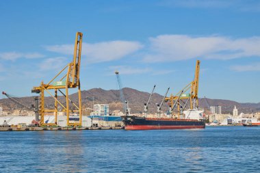 Malaga, İspanya - 06 Ocak 2024: Kargo gemisi iskele vinçlerinin yanındaki limanda yükleme için kullanılıyor.