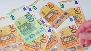 100 Euro 'luk banknotları masaya fırlatan kadınların yakın çekimi.