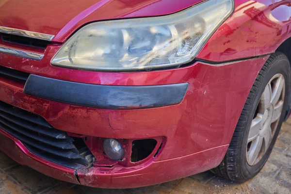 Kırmızı bir arabanın tırmalanmış tamponunun yakın çekimi. Araba kazası ya da kaza. Kırık araç detayı. Park sorunları kavramı.