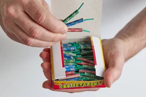 A man opens a box of firecrackers. Close-up of a man\'s hands opening a box.