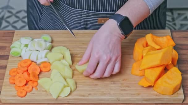 カボチャのスープを準備するために野菜をチョッピングする女性の手のクローズアップ カーロット ジャガイモ カボチャ — ストック動画