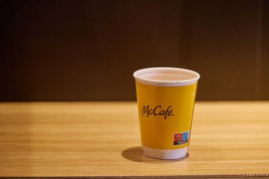 Masanın üzerinde sarı kağıt kahve fincanı. McCafe zamanı. Valencia, İspanya - 16 Mart 2024.