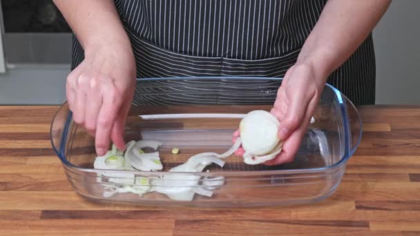 女人把洋葱圈放在玻璃器皿的底部 在家做饭 — 图库视频影像
