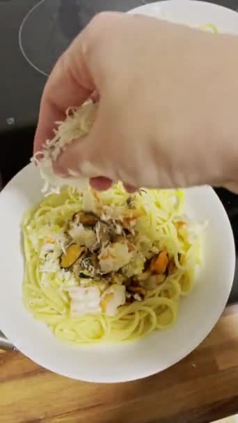 Kvinnan Lagar Spaghetti Med Skaldjur Kvinnlig Handströssel Riven Ost Spaghetti — Stockvideo